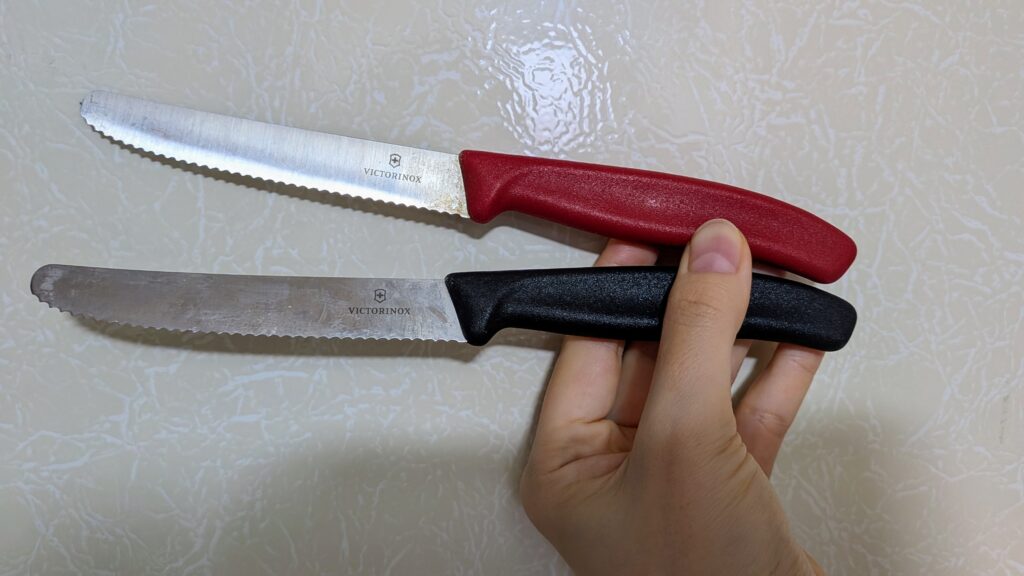 VICTORINOX(ビクトリノックス)スイスクラシック トマト&テーブルナイフ2本を持つ写真。上が赤、下が黒。